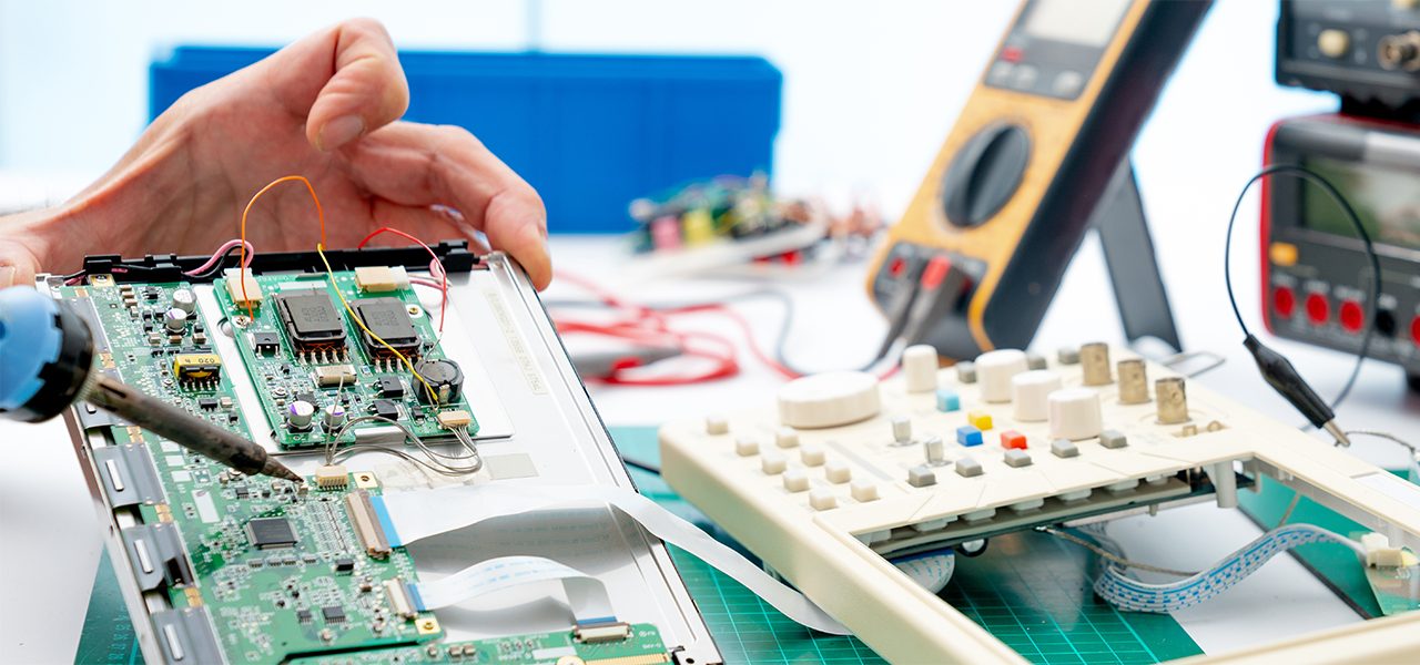 Technician repairing a circuit board with a soldering iron